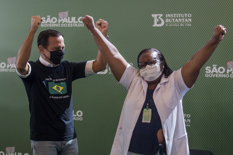 Nurse Monica Calazans, 54, and the Governor of Sao Paulo Joao Doria celebrate after she got her shot of the COVID-19 vaccine produced by China’s Sinovac Biotech Ltd, at the Hospital das Clinicas in Sao Paulo, Brazil, Sunday.