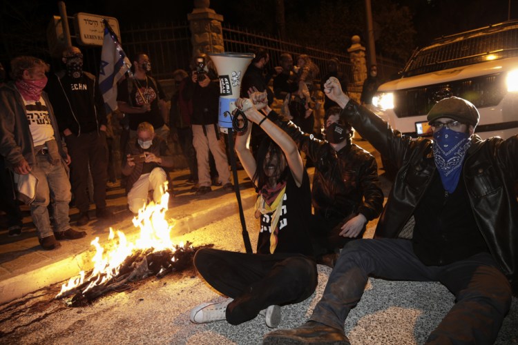 Israeli protesters block a road during a demonstration against Israeli Prime Minister Benjamin Netanyahu near his official residence in Jerusalem during the third nationwide coronavirus lockdown Saturday.
