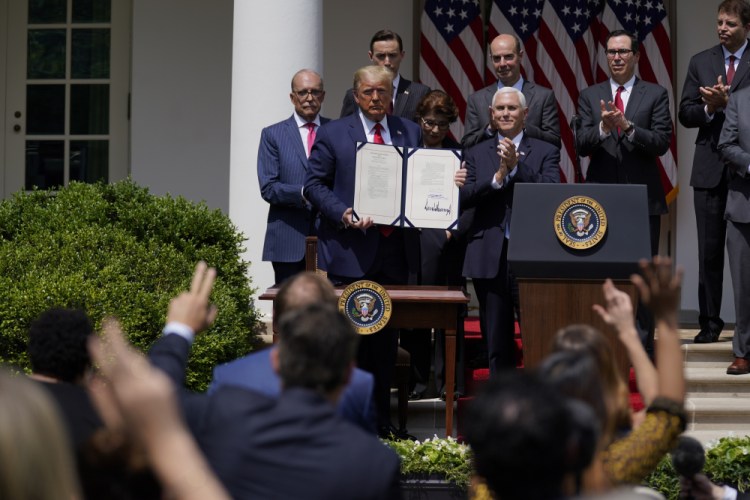 President Trump poses for a photo after signing the Paycheck Protection Program Flexibility Act during a news conference June 5 in the Rose Garden of the White House in Washington. 