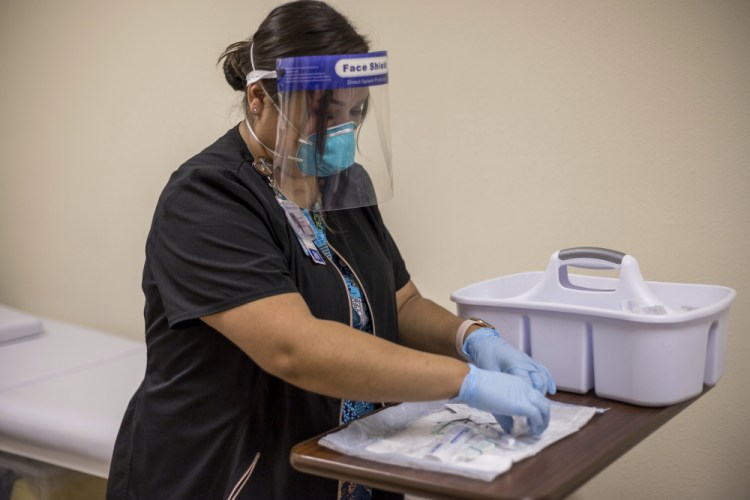 Registered nurse Starla Garcia prepares a coronavirus vaccine in Chinle, Ariz., on Tuesday for someone who enrolled in the COVID-19 vaccine trials on the Navajo Nation and initially received a placebo.