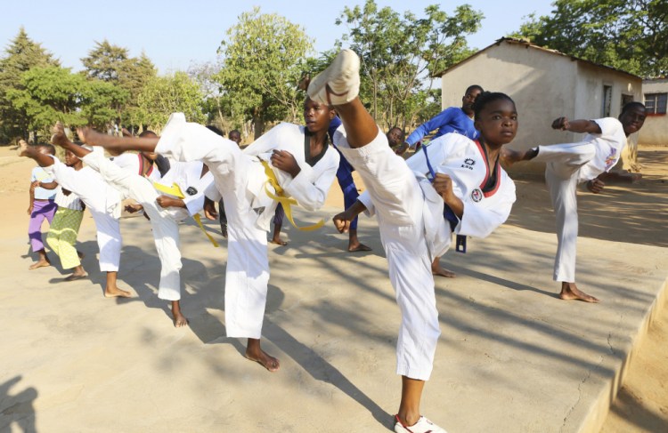 Natsiraishe Maritsa, second right, goes through taekwondo kicking drills during a practice session with young boys and girls in the Epworth settlement in Zimbabwe on Nov. 7, 2020. An estimated 30 percent of girls are married before reaching 18, according to the United Nations Children’s Fund. 