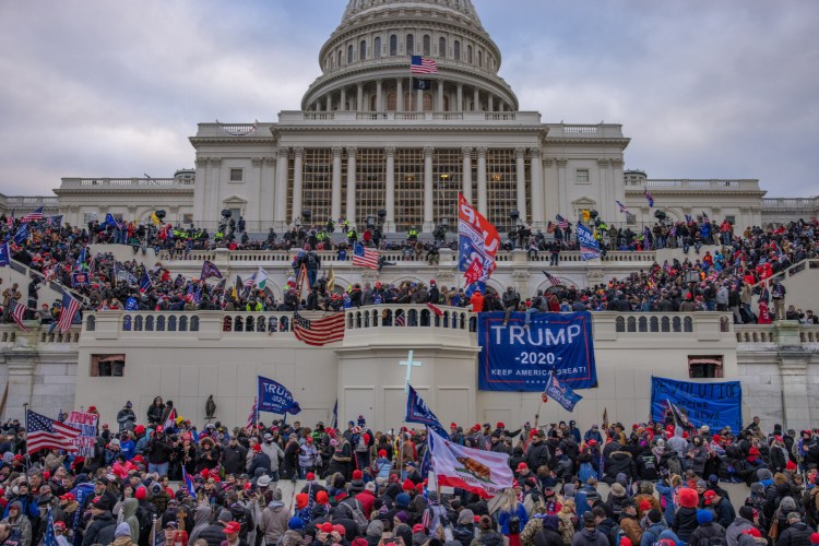 Supporters of President Trump mob the U.S. Capitol on Jan. 6. Five people died, including Capitol Police Officer Brian Sicknick, who was hit in the head with a fire extinguisher. A sixth person, another Capitol Police officer, later died by suicide.
