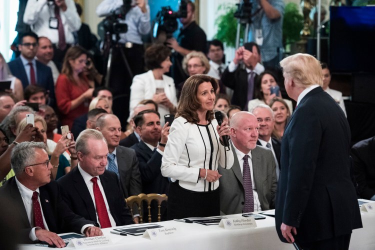 President Trump talks with Northrop Grumman CEO Kathy Warden during a "Pledge to America's Workers" event in the East Room of the White House in 2018. The company hasn't released a statement explaining the donation halt.