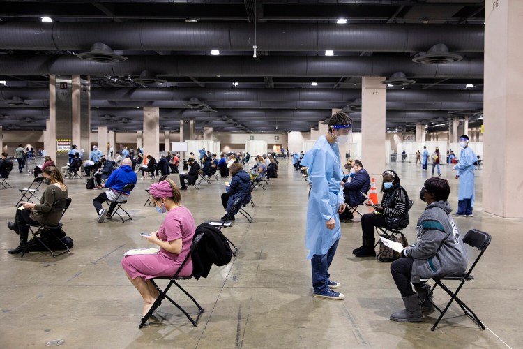People wait in an observation area after receiving a coronavirus vaccine at the mass-vaccination site set up by Philly Fighting COVID at the Pennsylvania Convention Center on Jan. 15. MUST CREDIT: photo for The Washington Post by Rachel Wisniewski.