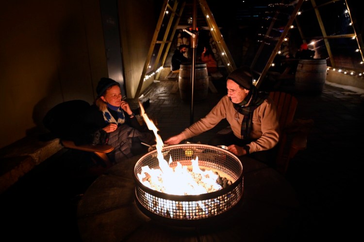 Bernard Cabrera of Portland warms his hands by a fire in the Oxbow beer garden in Portland on a Friday evening in early February. He and his wife, Jennifer Wolcott, were enjoying dinner at the brewery. They love Portland's food scene and are hopeful it will survive the pandemic. "I have faith, seeing the entrepreneurial spirit in this town, and the creativity, and the incredible talent of the chefs here," Wolcutt said.  