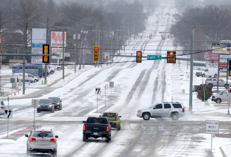 Tulsa's streets are covered in snow as a winter storm moves in to northeast Oklahoma on Sunday. 