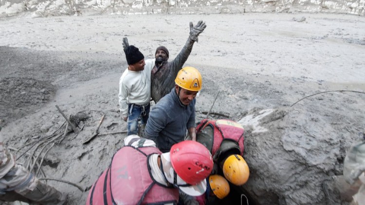 A man reacts after he was pulled out from beneath the ground by ITBP personnel during rescue operations after a portion of Nanda Devi glacier broke off Sunday in Tapovan area of the northern state of Uttarakhand, India.