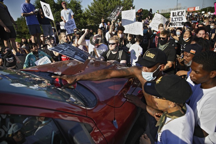 Protesters surround a truck May 31 shortly before it drove through the group injuring several on Interstate 244 in Tulsa, Okla. The group was protesting the killing of George Floyd by Minneapolis police on May 25 and commemorating the 1921 Tulsa Race Massacre.

