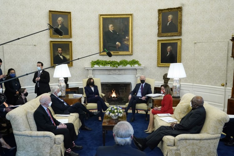President Joe Biden, accompanied by Vice President Kamala Harris, speaks with House Speaker Nancy Pelosi and House Majority Whip James Clyburn, right, House Majority Leader Steny Hoyer, seated second left, and Rep. Peter DeFazio, D-Or., seated left, and Rep. John Yarmuth, D-Ky., foreground, in the Oval Office of the White House, Friday, Feb. 5, in Washington. 