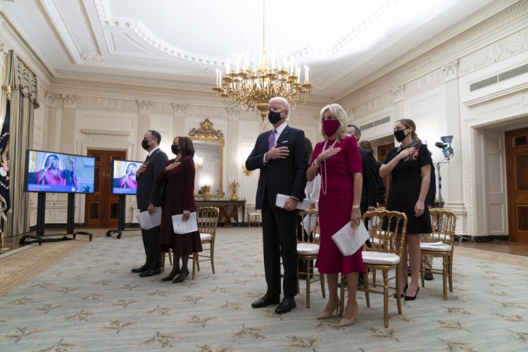 Doug Emhoff, left, Vice President Kamala Harris, President Joe Biden, and first lady Jill Biden, stand during a performance of the National Anthem during a virtual Presidential Inaugural Prayer Service, in the State Dining Room of the White House on Jan. 21. Biden addressed the National Prayer Breakfast, a Washington tradition that calls on political combatants to set aside their differences for one morning. 