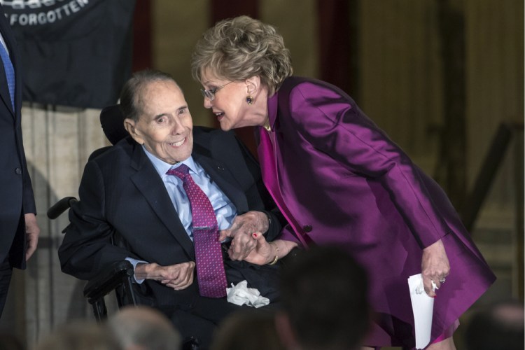 FILE - In this Jan. 17, 2018 file photo, former Senate Majority Leader Bob Dole smiles as he gets a kiss from his wife Elizabeth Dole as he is honored with a Congressional Gold Medal, at the Capitol in Washington. A political icon and 1996 Republican presidential nominee, Dole says he has been diagnosed with stage 4 lung cancer. 