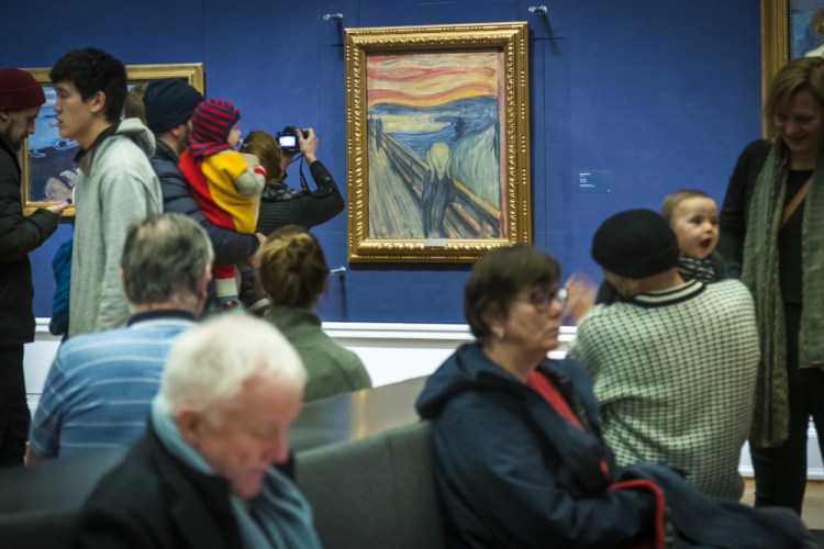 People look at "The Scream" at the National Gallery in Oslo in 2019. A Norwegian museum says a small, barely visible sentence written on Edvard Munch’s 1893 masterpiece was penned by the Norwegian painter himself.