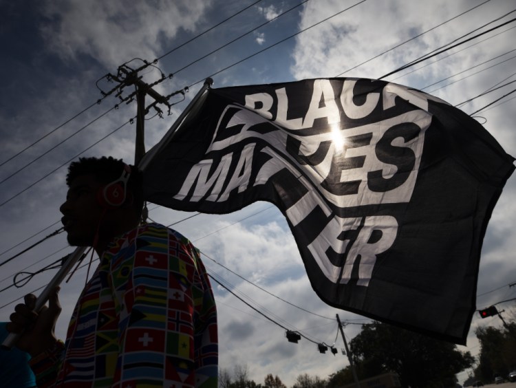 MD Crawford carries a Black Lives Matter flag before a march in La Marque, Texas, in December to protest the shooting of Joshua Feast, 22, by a La Marque police officer. The Black Lives Matter Global Network Foundation is now building infrastructure to catch up to the speed of its funding and plans to use its endowment to become known for more than protests after Black Americans die at the hands of police or vigilantes. 