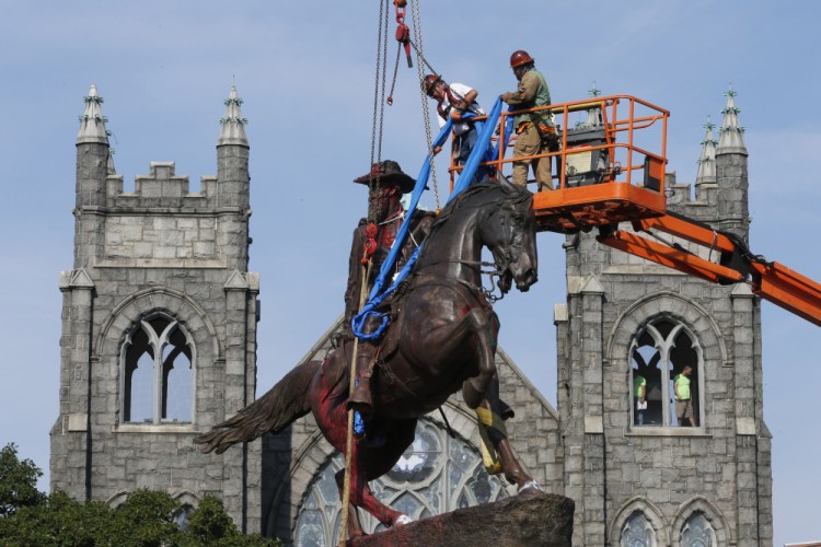Crews attach straps to the statue Confederate General J.E.B. Stuart on Monument Avenue in Richmond, Va. in July 2020. At least 160 Confederate symbols were taken down or moved from public spaces in 2020. 