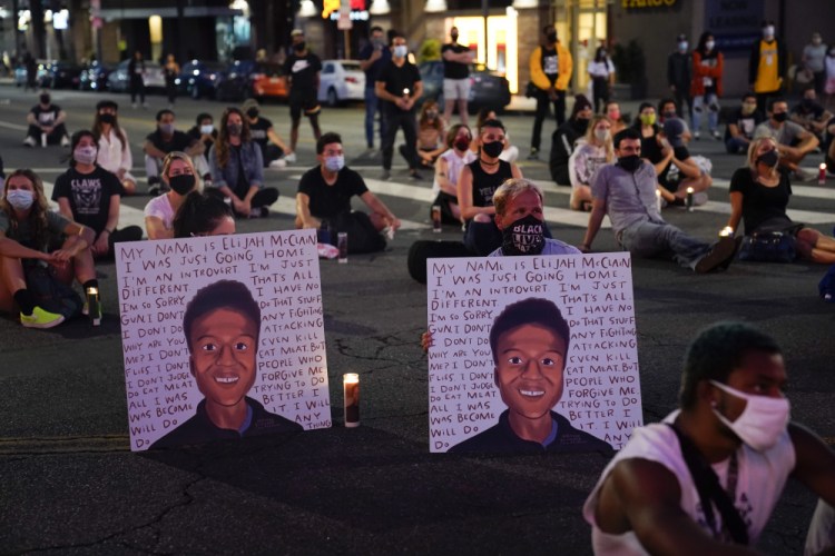 People hold a candlelight vigil for Elijah McClain during a candlelight vigil for McClain on Aug. 24, 2020, outside the Laugh Factory in Los Angeles.