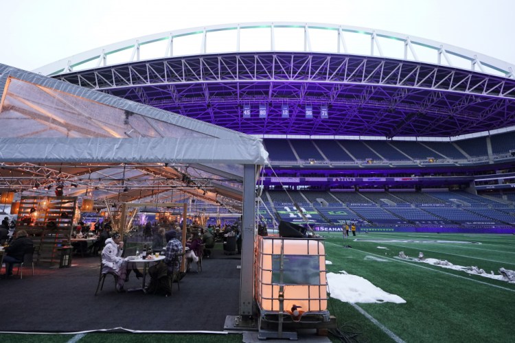 People eat dinner in an outdoor dining tent set up at Lumen Field, the home of the Seattle Seahawks NFL football team, on Feb. 18.

