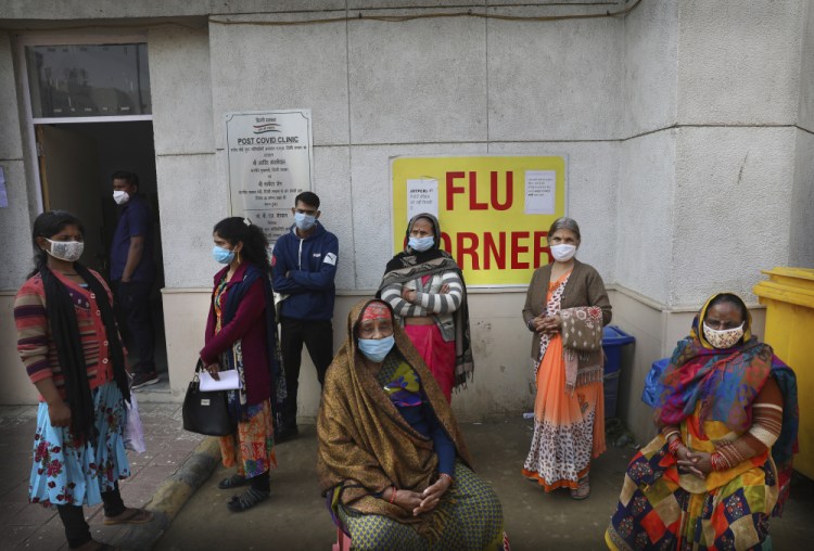 People wait outside a health center to get tested for COVID-19 in New Delhi, India, on Thursday.

