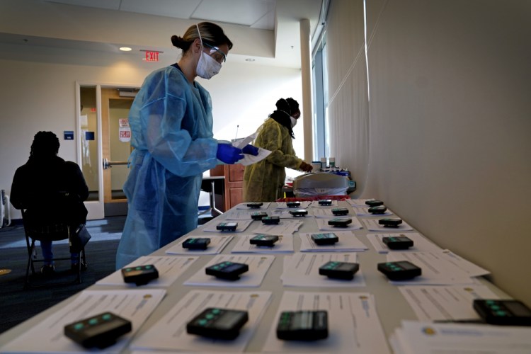 Certidied medical assistants conduct coronavirus rapid testing in the student health center at North Carolina Agricultural and Technical State University in Greensboro, N.C., Wednesday, Feb. 3, 2021. As vaccinations slowly ramp up, some experts say turning to millions more rapid tests that are cheaper but technically less accurate may improve the chances of identifying sick people during the critical early days of infection, when they are most contagious. (AP Photo/Gerry Broome)