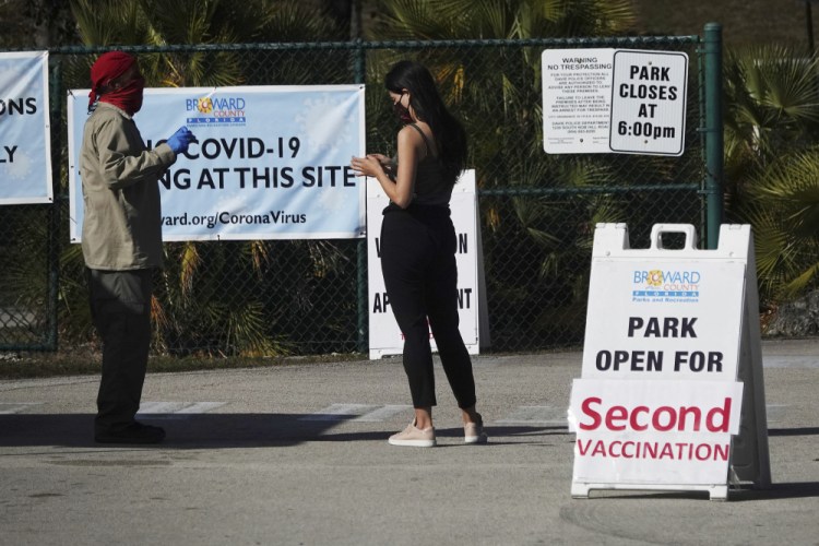 A woman asks directions at the entrance to Vista View Park in Davie, Fla., where a COVID-19 vaccination site has opened for second doses. (Joe Cavaretta/South Florida Sun-Sentinel via AP, File)