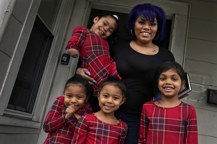 Dinora Torres, a MassBay Community College student, poses with her four daughters on the front porch of their home Jan. 14 in Milford, Mass. From front left are Davina, Alana and Hope, with Faith in Dinora's arms. 
