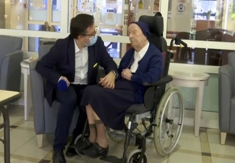 Sister Andre is interviewed by an official at the Sainte Catherine Laboure Nursing Home in Toulon, France, on Tuesday. The 116-year-old nun tested positive for COVID-19 virus in mid-January but just three weeks later she is fit as a fiddle – albeit it in her regular wheelchair.