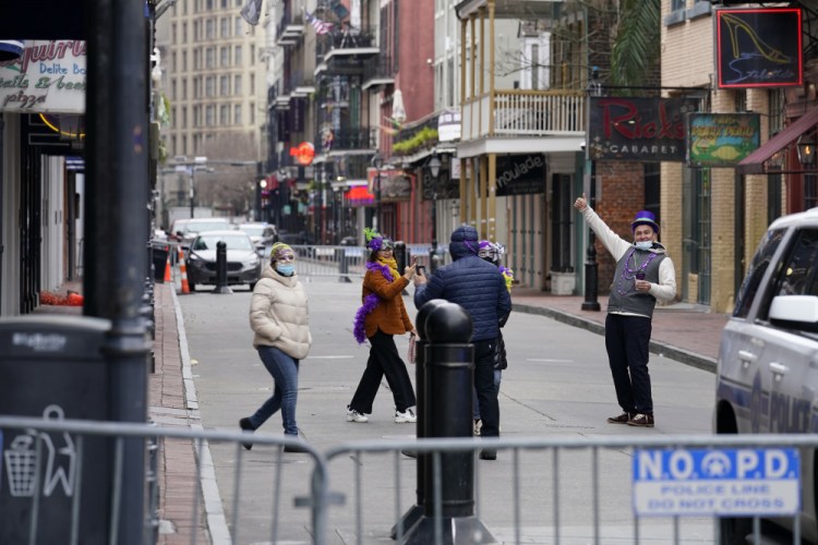 Tourists take photos on a nearly deserted Bourbon Street during Mardi Gras in the French Quarter of New Orleans on Tuesday.

