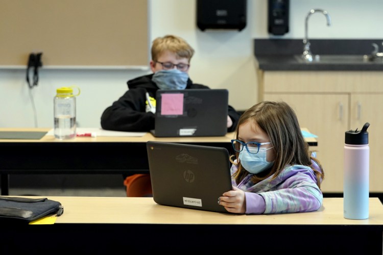 Students work in a fourth-grade classroom at Elk Ridge Elementary School in Buckley, Wash., this month. Amid mounting tensions about school reopening, the Centers for Disease Control and Prevention released long-awaited guidance on Friday. 