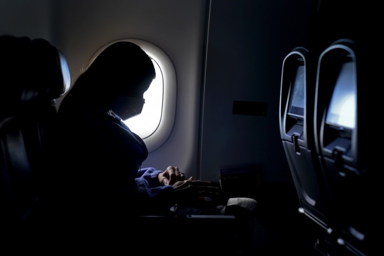 A passenger travels on a Delta flight Wednesday after taking off from Hartsfield-Jackson International Airport in Atlanta. Amid fears of new variants of the virus, new restrictions on movement have hit just as people start to look ahead to what is usually a busy time of year for travel. 

