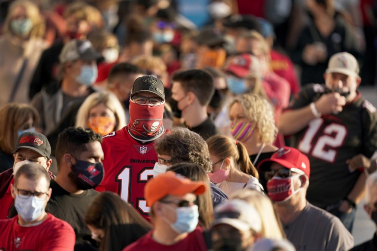 People wait in line Thursday for an exhibit at the NFL Experience in Tampa, Fla. The city is hosting Sunday's Super Bowl football game between the Tampa Bay Buccaneers and the Kansas City Chiefs. (AP Photo/Charlie Riedel, File)