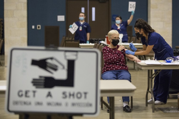 Edna Becker receives the Moderna coronavirus vaccine from nurse Patricia Torres at the mass vaccination clinic at the New Braunfels Civic/Convention Center in New Braunfels, Texas, in January. Some governors, public health directors and committees advising them are holding key discussions behind closed doors, including debates about who should be eligible for the shots and how to best distribute them. 