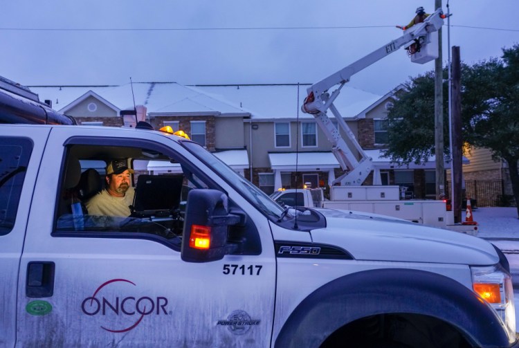 An Oncor crew works on along Elsie Faye Higgins Street as power outages continue across the state after a second winter storm brought more snow and continued freezing temperatures to North Texas on Wednesday, Feb. 17, in Dallas. 