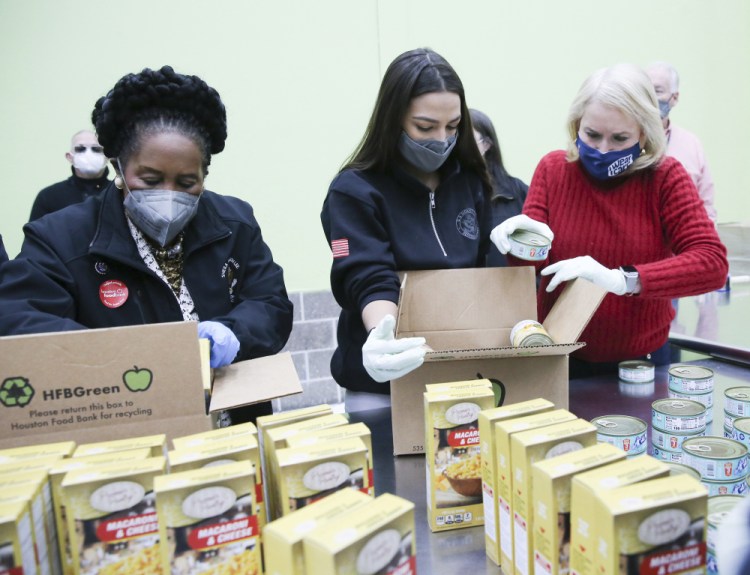 From left, U.S. Reps. Sheila Jackson Lee,  Alexandria Ocasio-Cortez  and Sylvia Garcia fill boxes at the Houston Food Bank on Saturday.

