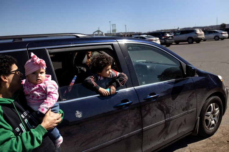 SOUTH PORTLAND, ME - MARCH 17: Keston Johnson-McDonnell, 6, sticks his head out of the window of his parents, Rebecca Johnson and Mark McDonnell, far left, 2005 minivan at Bug Light Park in South Portland on Wednesday, March 17, 2021. The couple is buying a new, more reliable car with the help of the stimulus money they are receiving. (Staff photo by Brianna Soukup/Staff Photographer)