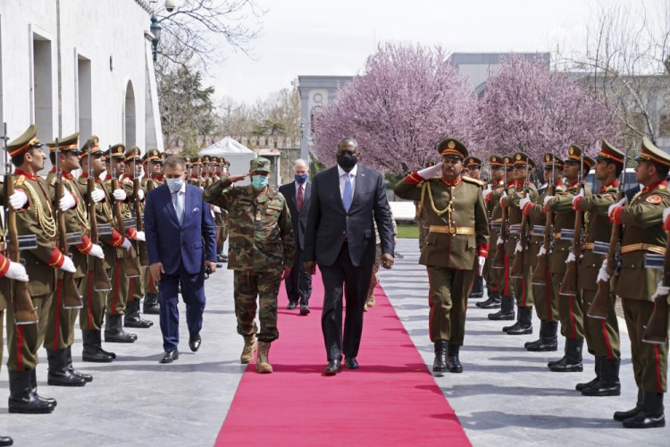 U.S. Defense Secretary Lloyd Austin, center, walks on the red carpet with Acting Afghan Minister of Defense Yasin Zia as they review an honor guard at the presidential palace in Kabul, Afghanistan, on Sunday. It was his first trip to Afghanistan as Pentagon chief. 