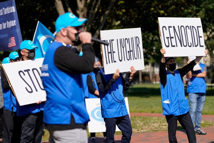 Holding signs saying "Stop the Uyghur Genocide," members of the Uyghur American Association rally in front of the White House, Thursday, Oct. 1, 2020, after marching from Capitol Hill in Washington, in support of the Uyghur Forced Labor Prevention Act which has passed the House and now will go on to the Senate. The bill prohibits some imports from Xinjiang and imposes sanctions for human rights violations. (AP Photo/Jacquelyn Martin)
