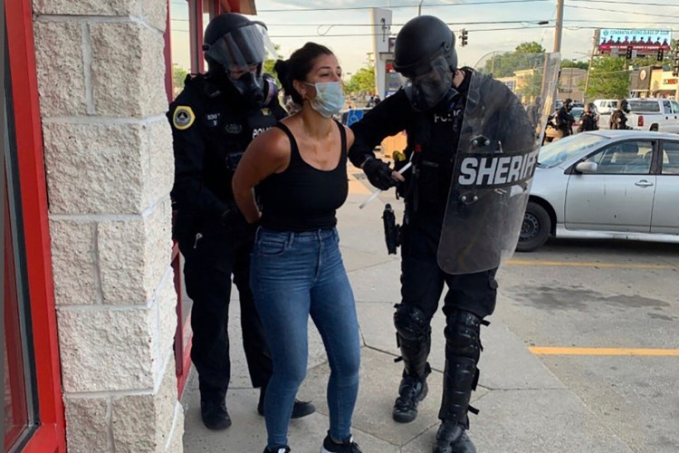 Police officers are shown arresting Des Moines Register reporter Andrea Sahouri after a Black Lives Matter protest she was covering on May 31, 2020, in Des Moines, Iowa. 