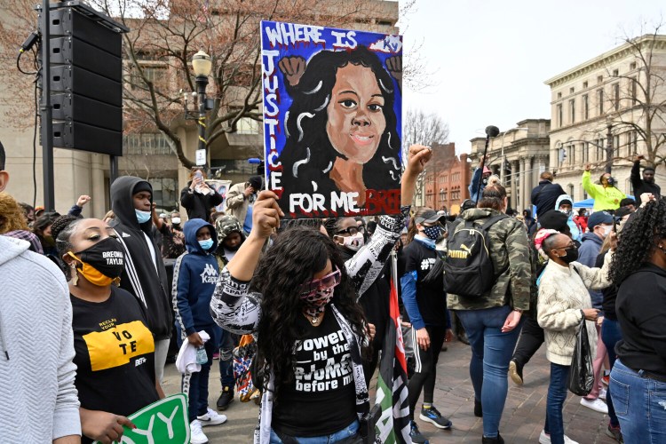 A protester displays a painting of Breonna Taylor during a rally on the one-year anniversary of her death at Jefferson Square Park in Louisville, Ky., on Saturday. 