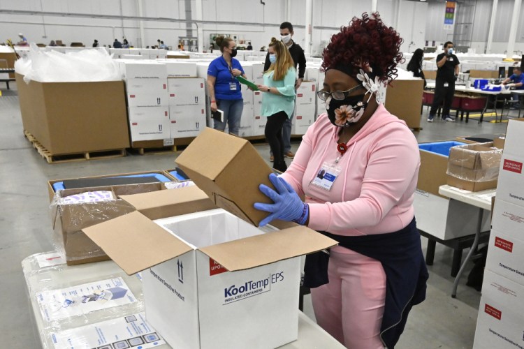 An employee with the McKesson Corporation packs a box of the Johnson & Johnson COVID-19 vaccine into a cooler for shipping from their facility Monday in Shepherdsville, Ky.