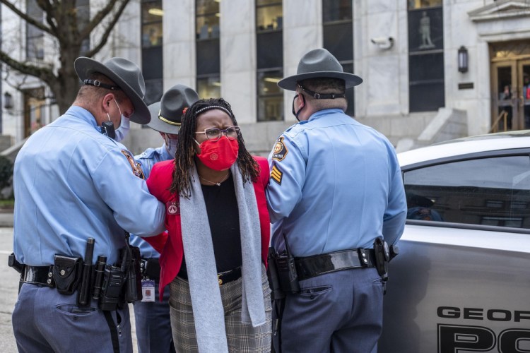 State Rep. Park Cannon, D-Atlanta, is placed into the back of a Georgia State Capitol patrol car after being arrested by at the Georgia State Capitol Building in Atlanta on March 25. Cannon was arrested by Capitol police after she attempted to knock on the door of Gov. Brian Kemp's office during his remarks after he signed into law a sweeping Republican-sponsored overhaul of state elections that includes new restrictions on voting by mail and greater legislative control over how elections are run. 