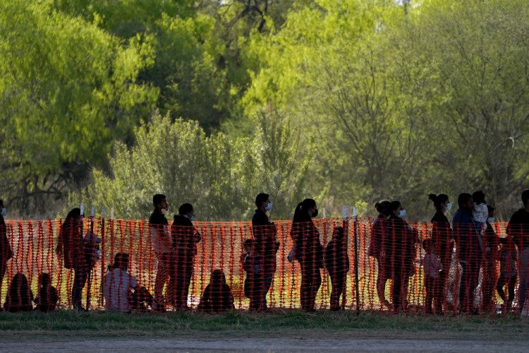 Migrants are in custody Friday at a U.S. Customs and Border Protection processing area under the Anzalduas International Bridge in Mission, Texas. 

