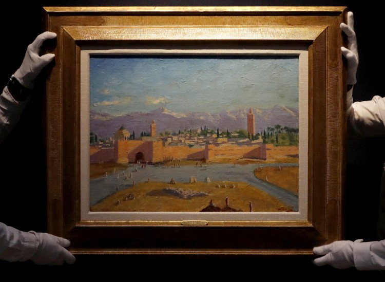 Christie's employees adjust an oil on canvas painting by Sir Winston Churchill painted in Jan. 1943 titled "Tower of the Koutoubia Mosque" during an pre-sale photo call at Christie's auction house in London. The Moroccan landscape painted by Winston Churchill and owned by Angelina Jolie sold at auction on Monday for more than $11.5 million, smashing the previous record for a work by Britain’s World War II leader. 