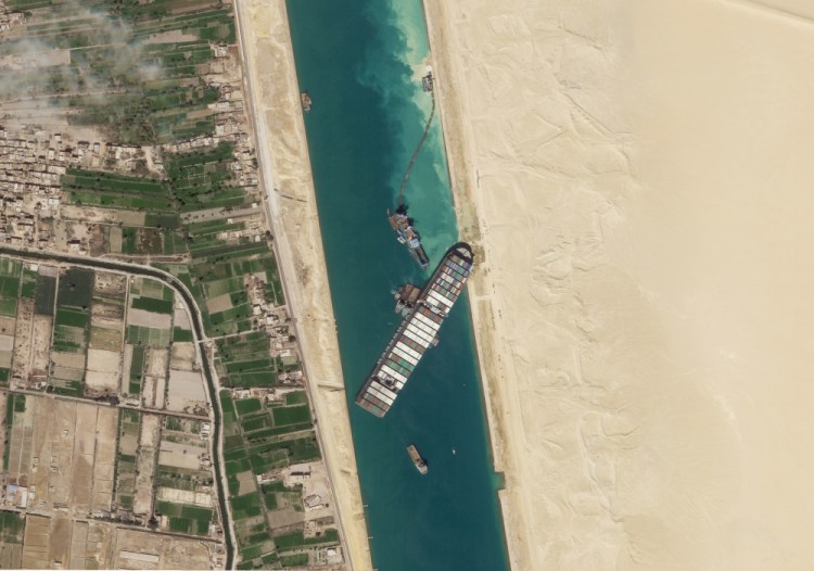 The cargo ship MV Ever Given sits stuck in the Suez Canal near Suez, Egypt, on March 28. Egyptian authorities say the ship cannot leave until its owners pay $900 million – a sum Egypt believes it is owed for the six-day blockage.