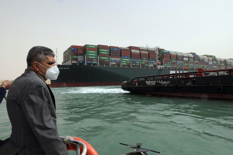Lt. Gen. Ossama Rabei, head of the Suez Canal Authority, investigates the situation with the Ever Given, a Panama-flagged cargo ship, on Thursday, days after it become wedged across the Suez Canal and blocked traffic in the vital waterway. An operation is underway to try to work free the ship, which further imperiled global shipping Thursday as at least 150 other vessels needing to pass through the crucial waterway idled waiting for the obstruction to clear. 