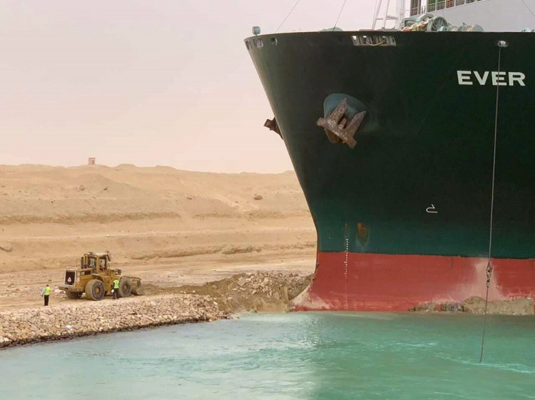 In this photo released by the Suez Canal Authority, a cargo ship, named the Ever Green, sits with its bow stuck into the wall Wednesday, March 24, after it turned sideways in Egypt’s Suez Canal, blocking traffic in a crucial East-West waterway for global shipping. 