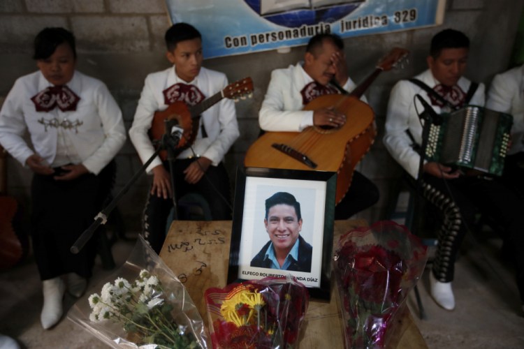 A framed portrait of Elfego Miranda Diaz, one of Guatemalan migrants who was killed near the U.S.-Mexico border in January, sits on top of the coffin that contains his remains during a wake in his home in Comitancillo, Guatemala, on Saturday.

