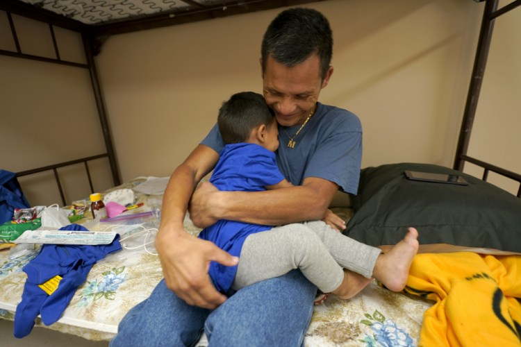 Elmer Maldonado, top, a migrant from Honduras, hugs his 1-year-old son at a shelter, Monday in Harlingen, Texas. They spent a week in immigration custody after crossing the Rio Grande through Texas to request asylum. His experience illustrates a cycle that is repeating itself thousands of times a week amid a dramatic rise in migrant children and families at the U.S.-Mexico border: They arrive in the middle of the night by the dozens and are kept at outdoor intake sites, then taken to overcrowded detention facilities well past the 72-hour court-imposed limit. 