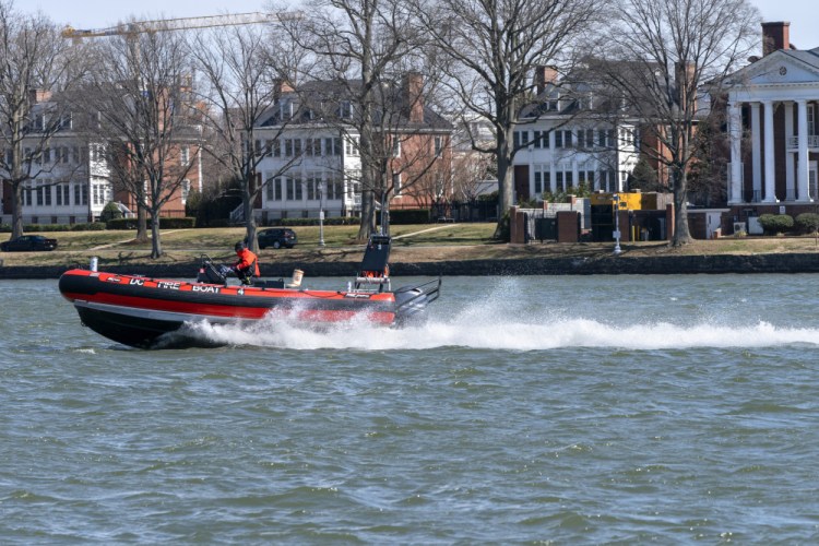 A District of Columbia Fire Boat checks buoys in the waterway next to Fort McNair, seen in background in Washington. The Army has erected more restricted area signs and placed cameras to monitor the Washington Channel. 