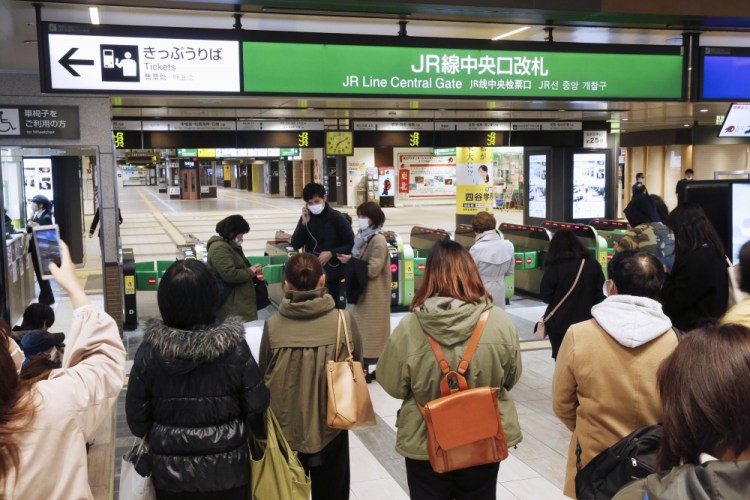 People gather in front of a ticket gate at a station as train services are suspended following an earthquake in Sendai, Miyagi prefecture, Japan on Saturday.
