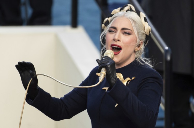 Lady Gaga, shown singing the national anthem during President-elect Biden's inauguration at the U.S. Capitol in Washington, was in Rome filming a movie when her dog walker was shot by two men who took off with two of her dogs. The dog walker is recovering and the dogs were returned. 
