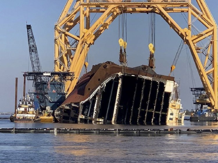 A towering crane straddles the capsized cargo ship Golden Ray, its interior decks exposed after the ship's bow was cut  and hauled away, off the coast of St. Simons Island, Ga. Salvage crews began Nov. 6 cutting the ship into giant chunks for removal. The vessel has been beached on its side since it overturned Sept. 8, 2019, soon after leaving port. 